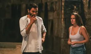 Coppia che discute durante un weekend fuori porta, lui pensieroso, lei con espressione preoccupata.