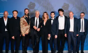 Il cast di Suburra - La serie posa sul red carpet. Un gruppo di attori e attrici, tra cui Alessandro Borghi e Giacomo Ferrara, sorridono alla fotocamera.