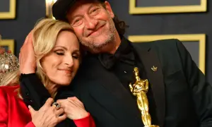 Il cast di coda, con i segni del cuore, celebra un momento d'oro. L'Oscar brilla, simbolo di un amore che supera ogni barriera.