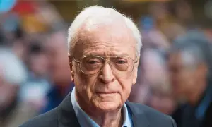 Michael Caine, icona del cinema, con occhiali e sguardo intenso. Un volto che ha segnato tanti film indimenticabili.
