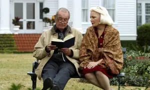 Il cast di "Le pagine della nostra vita" seduto su una panchina, un uomo legge un libro, una donna lo ascolta con attenzione.