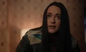 La protagonista di Resident Alien, con un'espressione sorpresa, indossa una giacca di pelle con dettagli colorati.