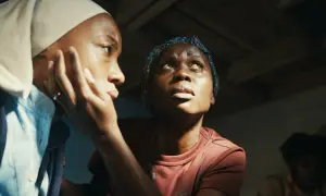 Due donne si guardano, una con la mano sul viso, l'altra alza lo sguardo. Un'immagine che evoca gli alberi della pace, speranza e resilienza.
