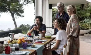 Una famiglia riunita per una colazione all'aperto, tra risate e sguardi pensierosi. Un momento di gioia e riflessione, una vera croce e delizia.