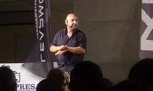 Giovanni Cacioppo, con un microfono all'orecchio, parla a un pubblico. La sua storia sulla malattia ispira.