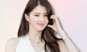 Han So Hee, con capelli castani lunghi, indossa orecchini a goccia e una collana d'oro.