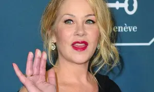Christina Applegate, icona di film e programmi TV, saluta con un sorriso smagliante e labbra rosse.