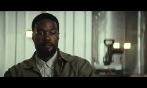 Primo piano di un uomo con barba, in abiti casual, in una scena della serie TV "Man on Fire".