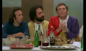 Il cast de "Il Pap'occhio" a tavola, tra bottiglie di vino e pane.