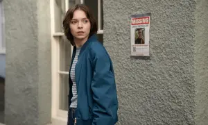 Ragazza preoccupata guarda un volantino "MISSING JAMIE REYNOLDS". La serie tv "come uccidono le brave ragazze" esplora misteri oscuri.