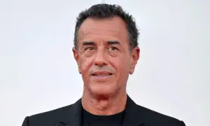 Matteo Garrone, regista italiano, con un sorriso enigmatico. La sua carriera è segnata da film potenti e visivamente sorprendenti.