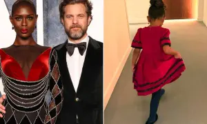 Joshua Jackson e la sua compagna, con la loro figlia che corre felice in un vestito rosso.