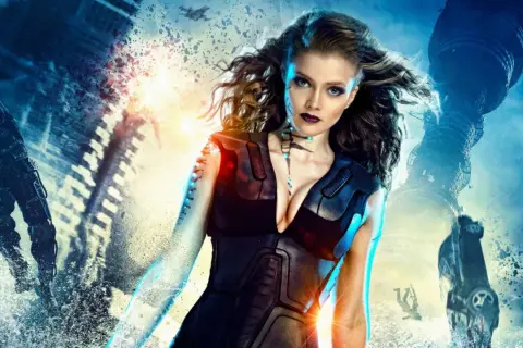 Il cast di Guardians: Il risveglio dei guardiani in un'epica battaglia futuristica. Una guerriera al centro, circondata da distruzione e macchine volanti.