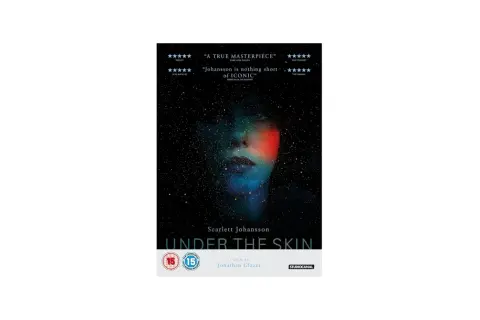 Volto di donna immerso nello spazio stellato, con luci colorate che sembrano penetrare sotto la pelle. Titolo del film "Under the Skin".