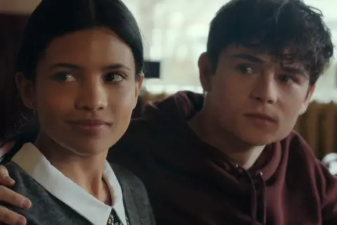 Il cast di uno splendido errore: un ragazzo e una ragazza si guardano con un'espressione pensierosa, lui le tiene un braccio attorno alle spalle.