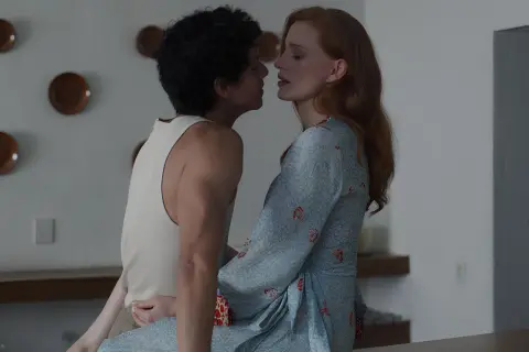Jessica Chastain in un film, vicina a un uomo con capelli ricci. Lei indossa un vestito azzurro con motivi rossi.