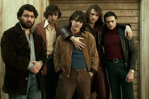 Cinque giovani uomini in abiti anni '70, un'immagine che evoca le origini di Gomorra.