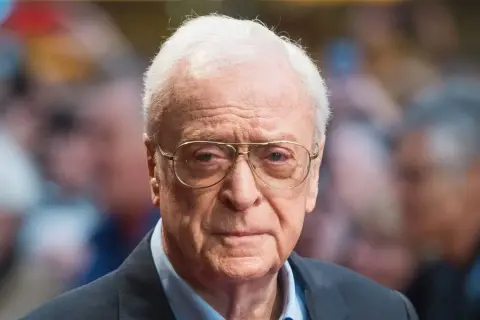 Michael Caine, icona del cinema, con occhiali e sguardo intenso. Un volto che ha segnato tanti film indimenticabili.
