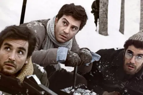 Tre uomini in un paesaggio innevato, con espressioni preoccupate. Ricorda un po' quando c'eravamo tanto amati, ma ora la situazione è tesa.