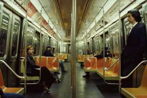 Una donna e un uomo in un vagone della metropolitana, seduti e in piedi. Un momento sospeso, forse l'inizio di una storia di un matrimonio.
