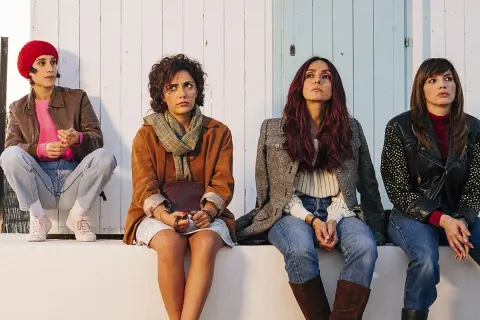 Quattro donne sedute, un'immagine dal film brave ragazze, con sguardi pensierosi rivolti verso l'alto.