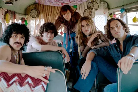 I membri di Daisy Jones & The Six, in un bus decorato, si preparano per un nuovo viaggio musicale.