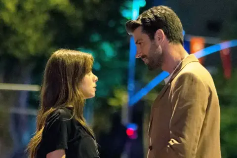 Una giovane donna e un uomo si guardano intensamente, un momento carico di tensione nella **innocence serie turca**.