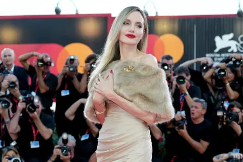 Angelina Jolie a Venezia, splendida sul red carpet, circondata da flash e fotografi.