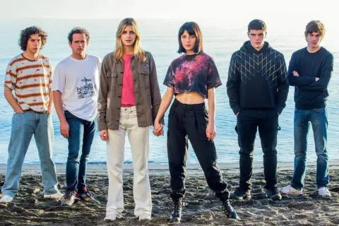 Il cast di Baby posa sulla spiaggia, con il mare sullo sfondo.