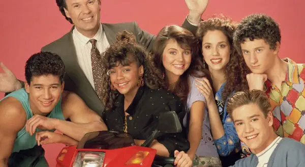 Cast del programma televisivo Bayside School posa sorridente con uno scooter rosso.