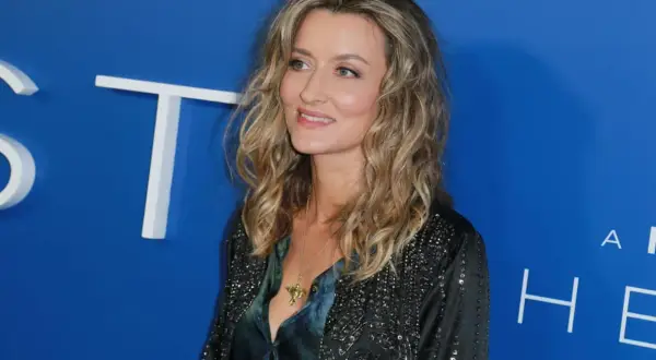 Natascha McElhone, attrice di film e programmi TV, sorride con un ciondolo dorato.