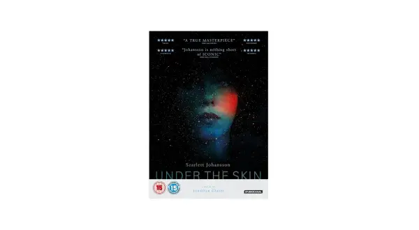 Volto di donna immerso nello spazio stellato, con luci colorate che sembrano penetrare sotto la pelle. Titolo del film "Under the Skin".