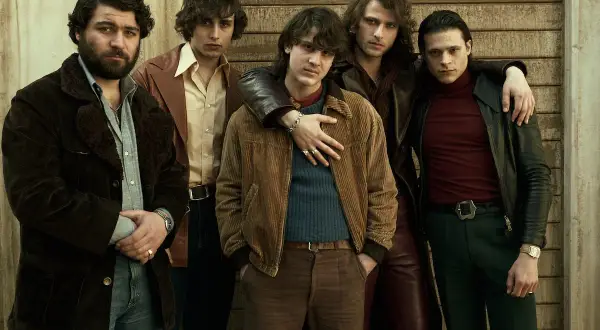 Cinque giovani uomini in abiti anni '70, un'immagine che evoca le origini di Gomorra.
