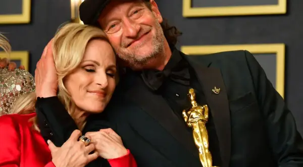 Il cast di coda, con i segni del cuore, celebra un momento d'oro. L'Oscar brilla, simbolo di un amore che supera ogni barriera.