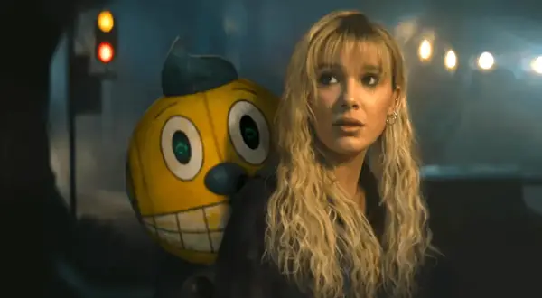 Ragazza bionda con un personaggio giallo dietro, in un'atmosfera cupa. Sembrano in uno stato elettrico di tensione.