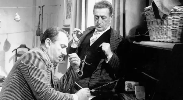 Totò e Peppino, nel cast di "La Malafemmina", discutono animatamente. Uno scrive, l'altro gesticola.