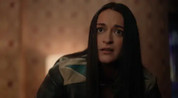 La protagonista di Resident Alien, con un'espressione sorpresa, indossa una giacca di pelle con dettagli colorati.