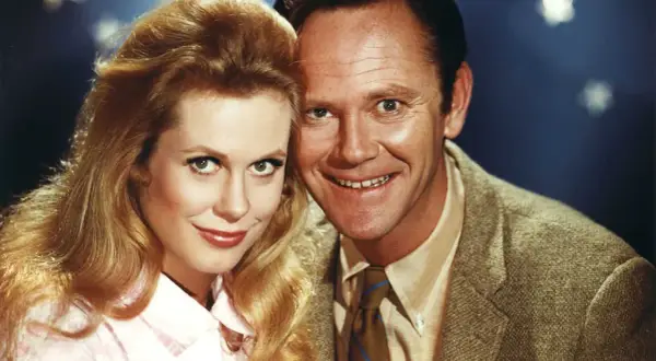 Il cast di Vita da strega: Elizabeth Montgomery e Dick York sorridono vicini, con lei che indossa una camicetta rosa e lui una giacca di tweed.