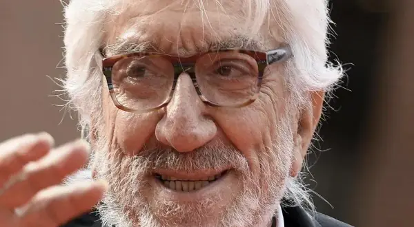 Ritratto di Gigi Proietti, con barba e capelli bianchi, occhiali da vista. La sua morte ha lasciato un vuoto nel cuore di molti.