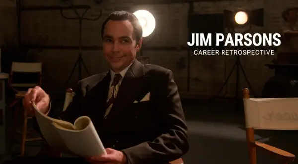 Jim Parsons, in un abito elegante, sfoglia un copione. Un omaggio ai suoi film e programmi TV.