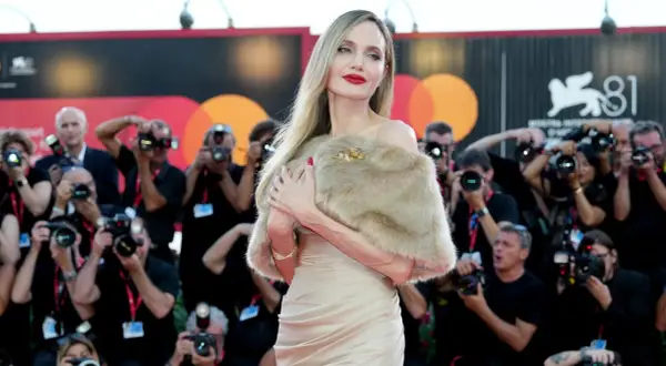 Angelina Jolie a Venezia, splendida sul red carpet, circondata da flash e fotografi.