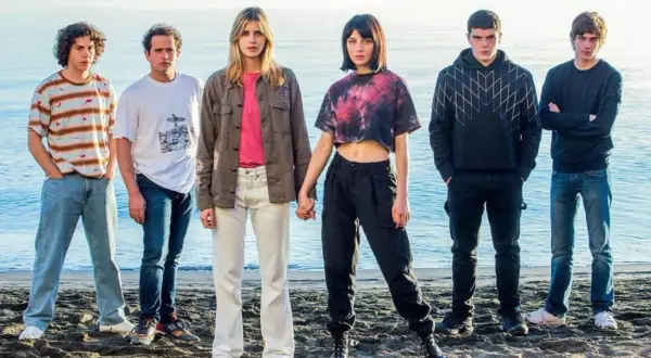 Il cast di Baby posa sulla spiaggia, con il mare sullo sfondo.