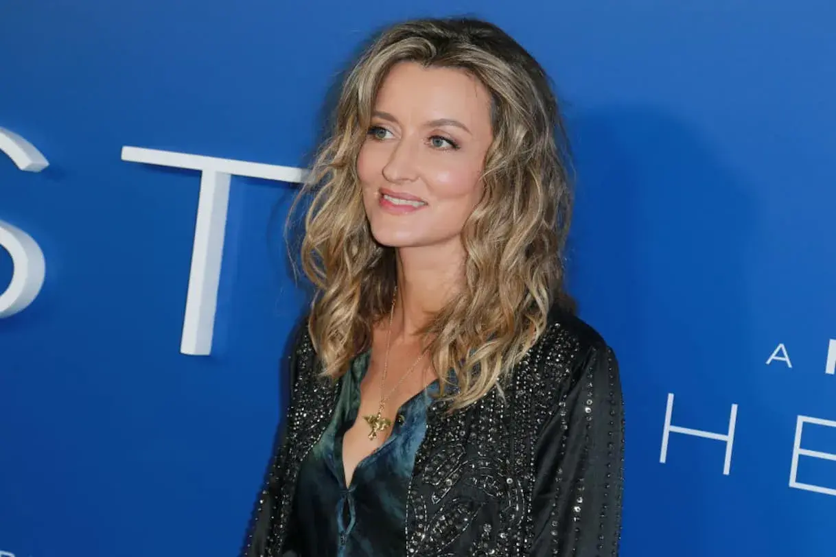 Natascha McElhone, attrice di film e programmi TV, sorride con un ciondolo dorato.