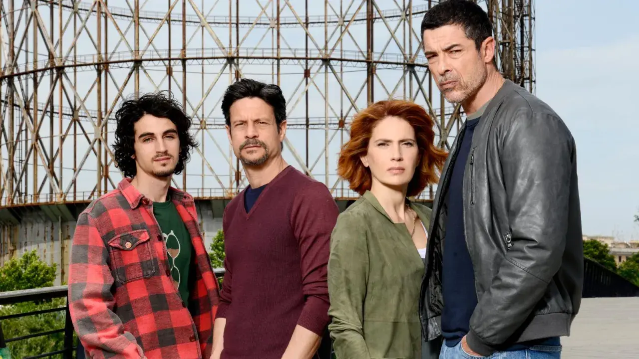 Il cast di "Io ti cercherò" posa davanti a una struttura metallica.