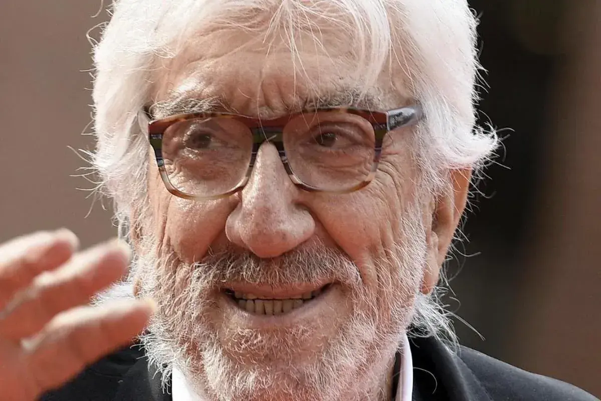 Ritratto di Gigi Proietti, con barba e capelli bianchi, occhiali da vista. La sua morte ha lasciato un vuoto nel cuore di molti.