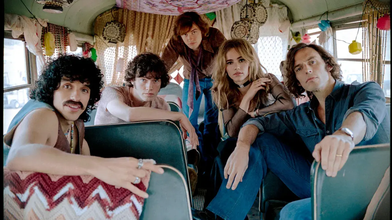 I membri di Daisy Jones & The Six, in un bus decorato, si preparano per un nuovo viaggio musicale.