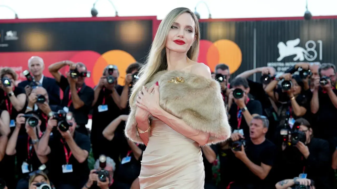 Angelina Jolie a Venezia, splendida sul red carpet, circondata da flash e fotografi.