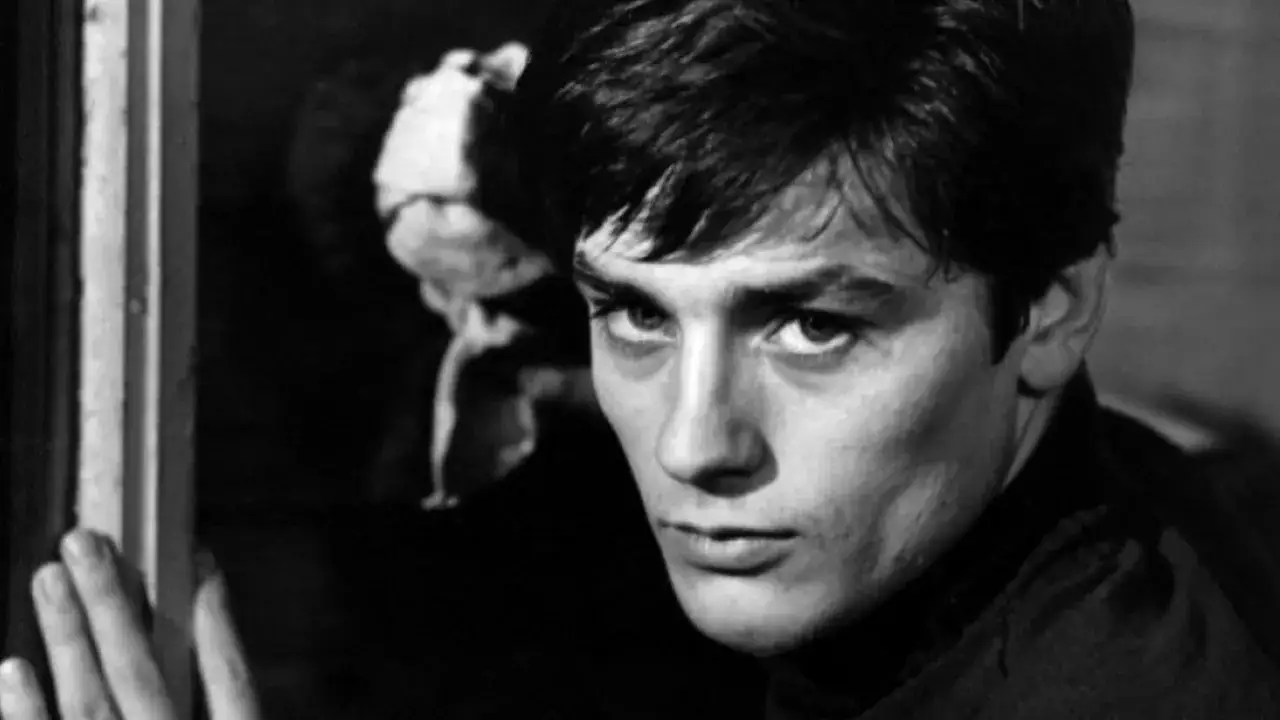 Alain Delon, icona di bellezza e talento, in un momento intenso che evoca i suoi film più belli.