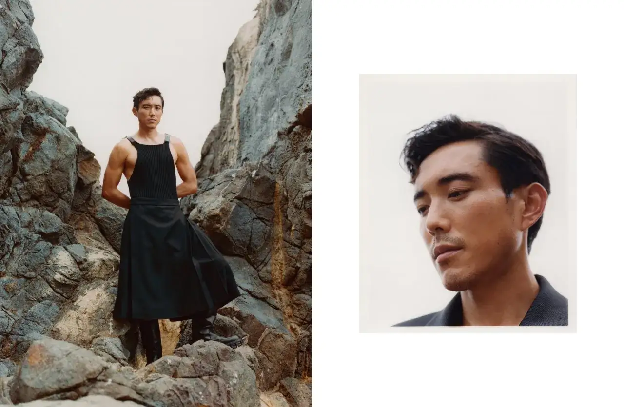 Justin Min, in un look audace, posa tra le rocce. Un primo piano rivela il suo sguardo intenso.