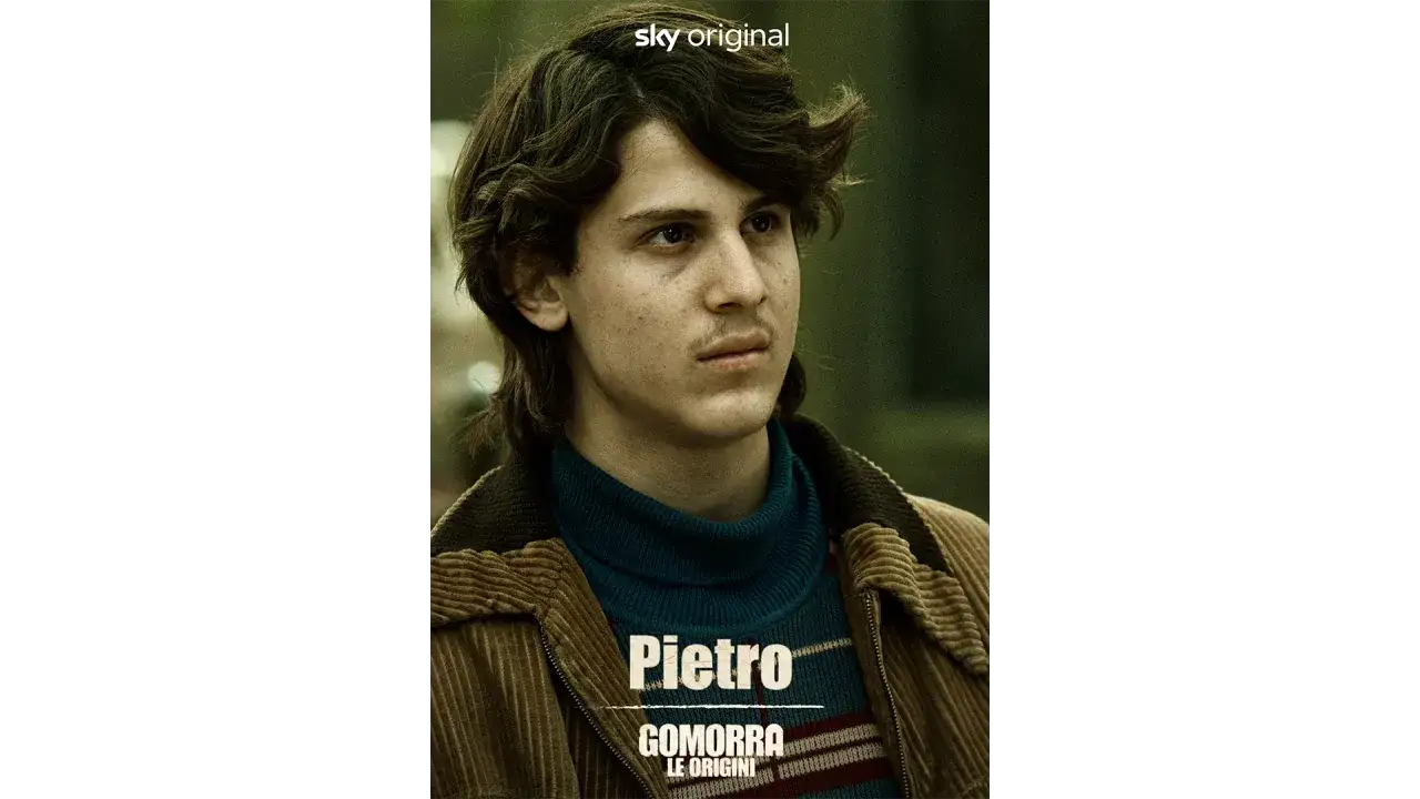 Pietro, protagonista di Gomorra: Le Origini, con sguardo intenso e abiti retr&ograve;.